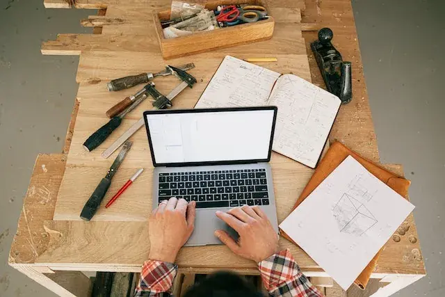 A laptop beside tools