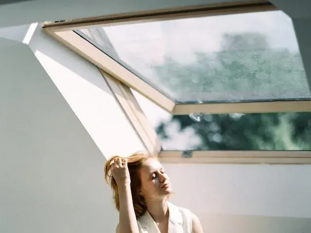 A woman sitting under a skylight