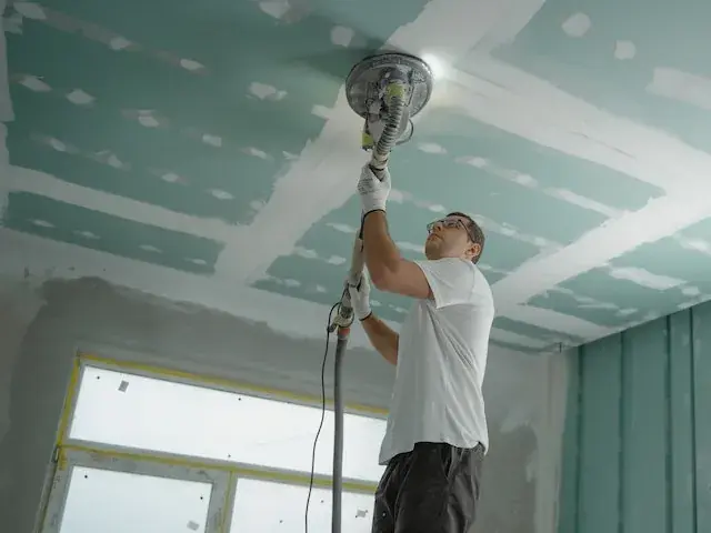 Man polishing ceiling for selling or buying a house with an old roof