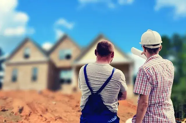 A builder showing houses in background