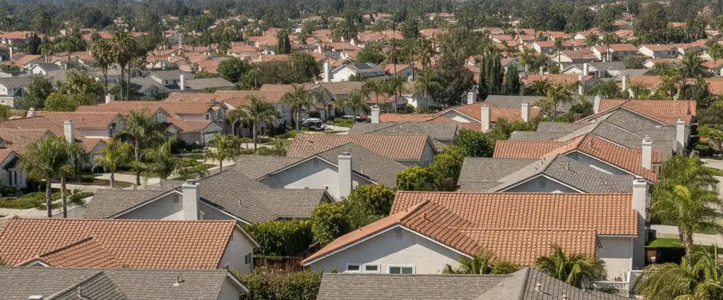 Well-maintained residential rooftops in Cerritos, Los Angeles County, California, with hazy coastal hills beyond
