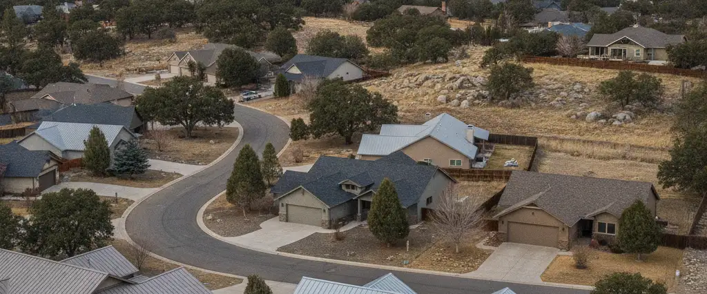 Well-maintained residential rooftops in Roseville, Placer County, California, with pine forest and the Sierra beyond