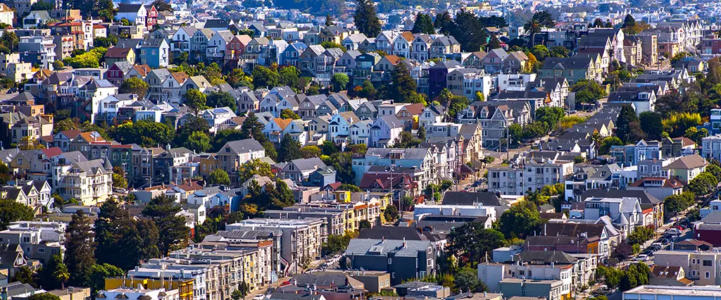 Row of attached San Francisco homes with flat rooftops behind parapet walls