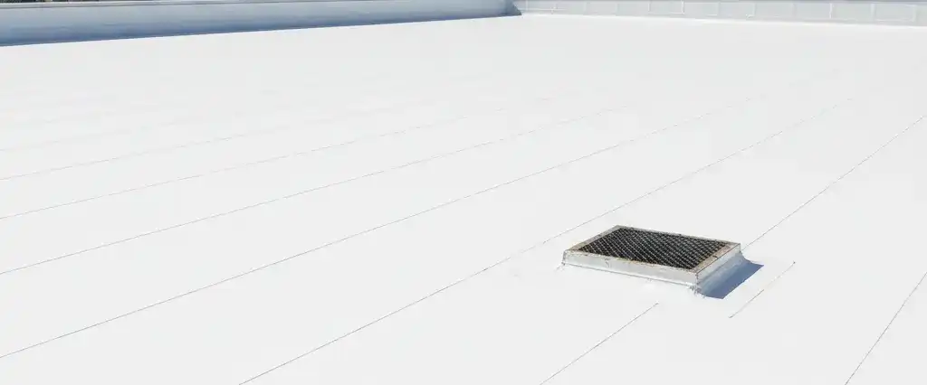 A flat white PVC membrane roof with heat-welded seams on a California commercial building