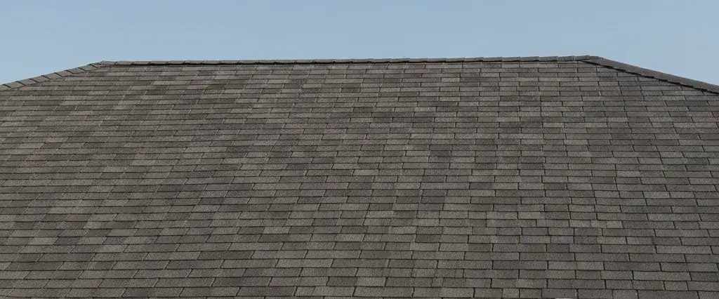 Residential rooftop mid-repair with new shingles and roofing tools staged under a clear sky