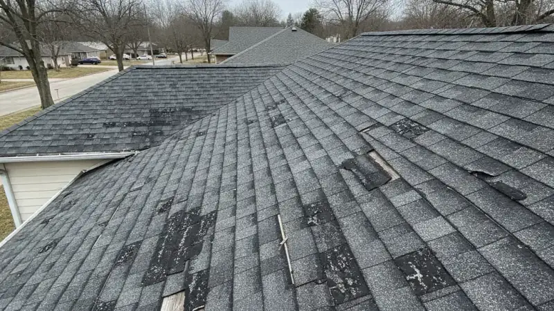 Deteriorated end-of-life roof with widespread cracking, bald spots, and exposed substrate