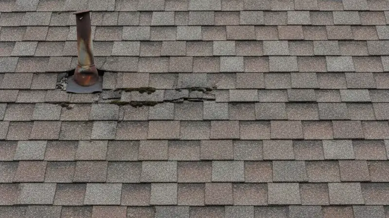 Old worn roof with widespread shingle wear at the end of its service life