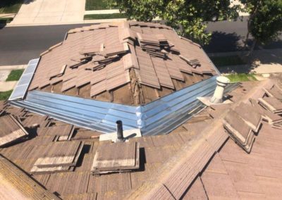 damaged brown flat tile roof in need of repair