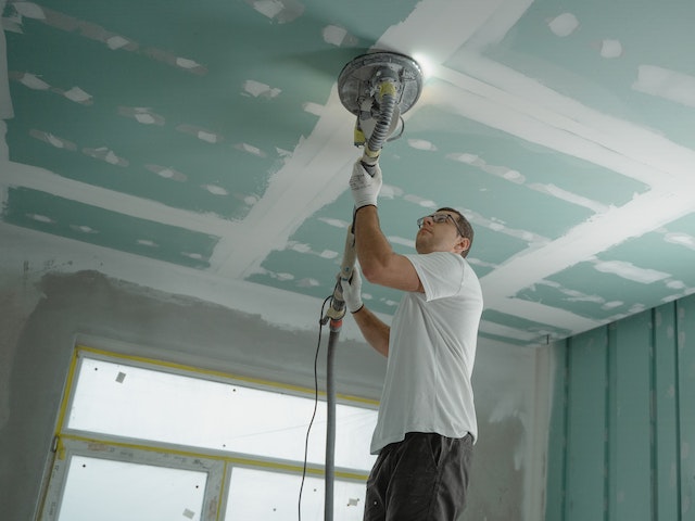 Man polishing ceiling for selling or buying a house with an old roof  