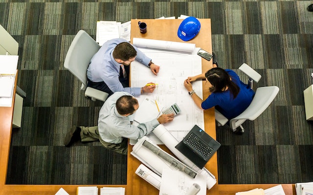 people around a wooden table discussing